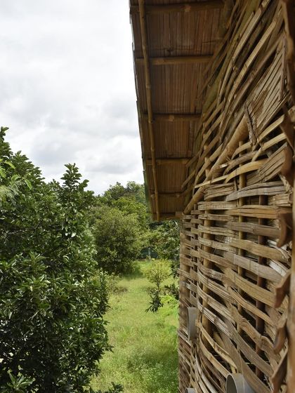 The exterior of the wattle-and-daub structure at Cheerville, showcasing the beautiful texture of the woven bamboo. This sustainable approach, created in collaboration with artisans from Assam and Meghalaya, uses bamboo instead of metal for the framework.