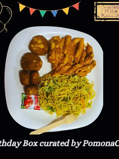 A sample birthday party meal, plated to show a delicious combination of hakka noodles, penne pasta, and vegetable cutlets. My birthday boxes are designed to be a complete, satisfying meal for guests of all ages.
