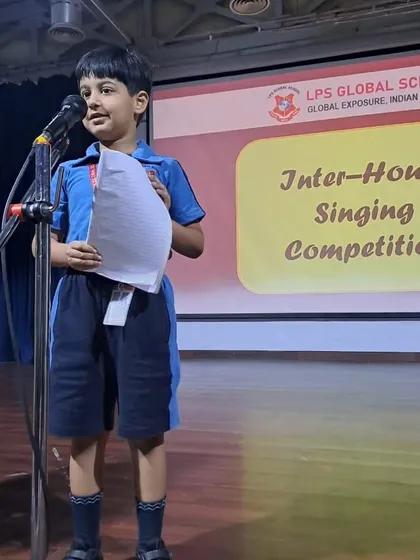 A student holds his lyrics sheet while singing, demonstrating his preparation and dedication for the competition.