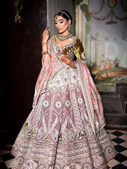 A masterpiece of a bridal look. This bride is the picture of elegance in her intricately embroidered pastel lehenga, with makeup that enhances her natural beauty.