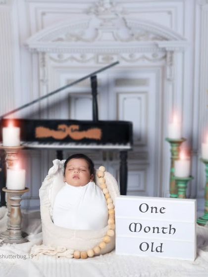 We can easily add milestone markers to any setup. Here, a lightbox announces that the baby is one month old, personalizing this elegant piano-themed portrait.