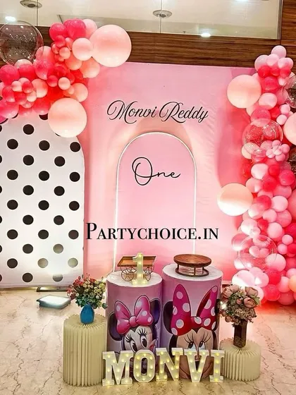 A modern and chic Minnie Mouse theme for a first birthday. We used a combination of polka-dot and solid pink backdrops, creative balloon arrangements, and light-up letters for a stylish celebration.