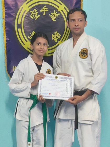 Awarding a 4th Kyu (green belt) certificate to a student who has shown great perseverance. Her progress in both kata and kumite has been impressive.