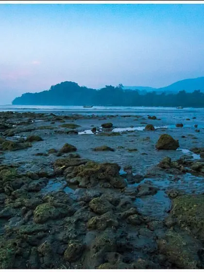 A blue hour shot of a beach in the Andaman Islands. The cool, soft light after sunset creates a serene and mysterious atmosphere over the unique rock formations.