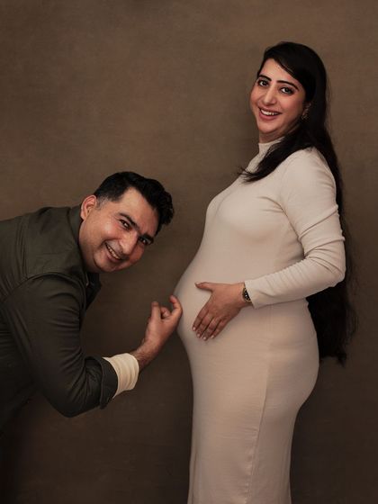A playful moment from the same session, with the dad-to-be listening to the baby bump.