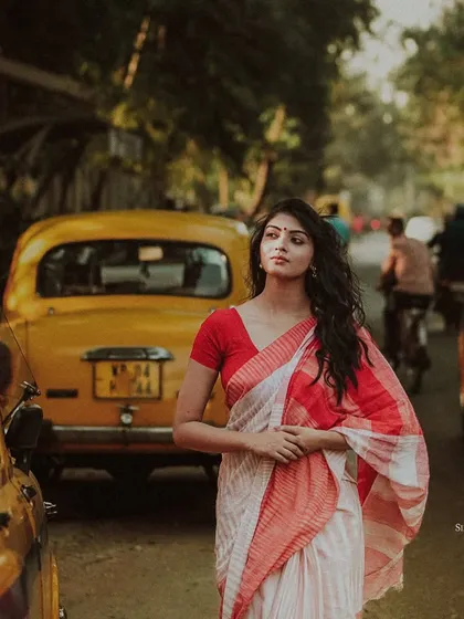 A model stands amidst the iconic yellow taxis of Kolkata. This shot captures the spirit of the city, blending traditional attire with the urban landscape.