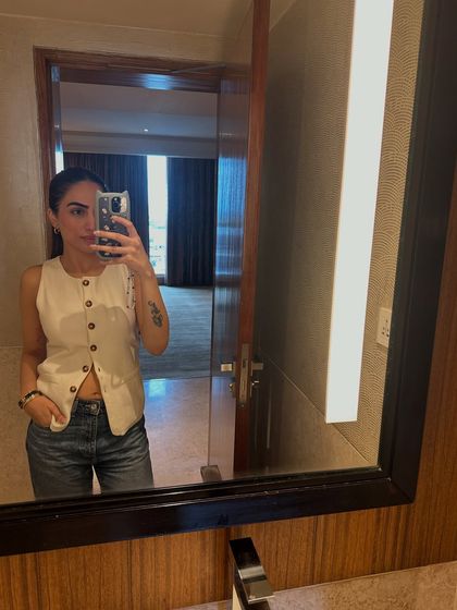 A mirror selfie from my hotel room in Bangalore. I’m wearing a casual outfit with a white vest and jeans, ready for a day in the city.