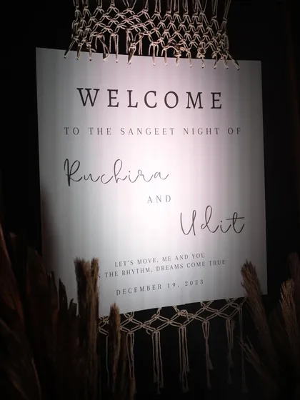 A chic and modern welcome sign for the Sangeet night, featuring elegant typography and macrame details. It's a stylish way to greet guests and kick off the evening's festivities.