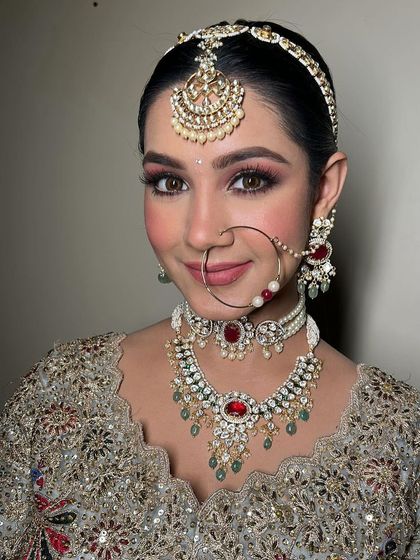 A close-up portrait of the bride. Her skin looks luminous, and the soft pink tones in her makeup create a romantic and youthful feel.