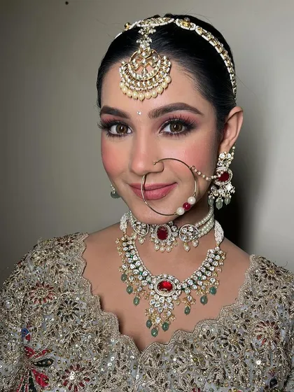 The complete bridal look with the nath (nose ring). Every detail, from the makeup to the jewelry, is carefully considered to create a cohesive and stunning appearance.