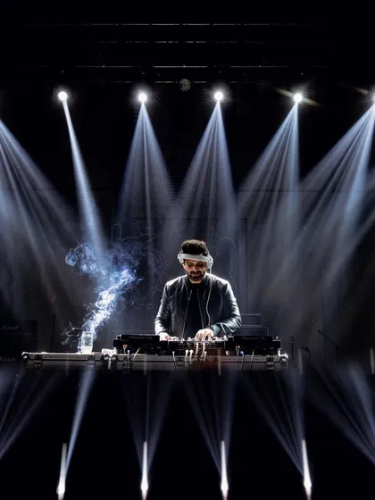 Setting the mood for a Sufi night in Jaipur. The DJ is captured in a dramatic shot under the spotlights, creating a soulful and electrifying atmosphere for the evening's musical event.