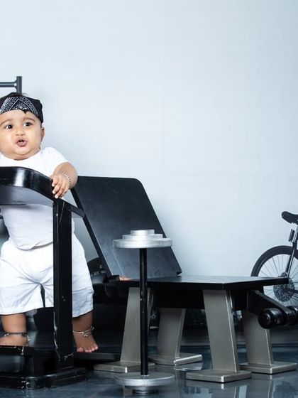 This baby is all smiles while standing on the treadmill, proving that a photoshoot can be a fun workout.