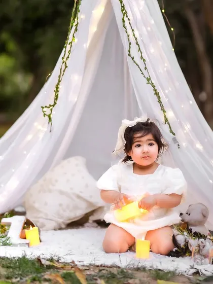 A magical moment in the woods. This little girl looks like a fairy in our enchanted tent setup, complete with glowing candles and lights.