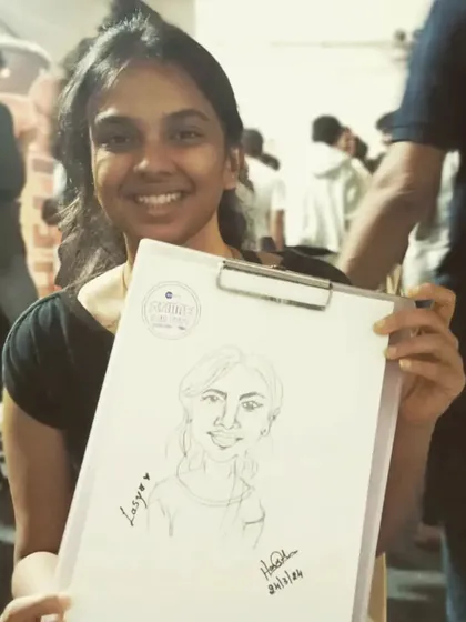 Another shot of Lasya with her caricature. The warm lighting of the event gives this photo a nice feel.