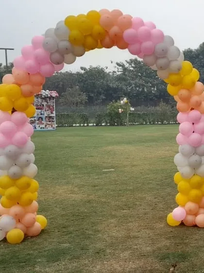 A simple yet beautiful balloon arch in pastel colors, perfect for an outdoor garden party entrance. It defines the celebration space and provides a lovely photo opportunity.
