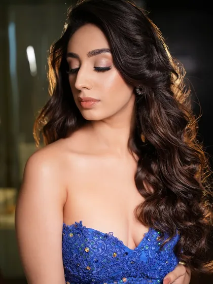 This shot highlights the beautiful contrast between the royal blue dress and the soft, neutral makeup. The look is understated yet powerful.