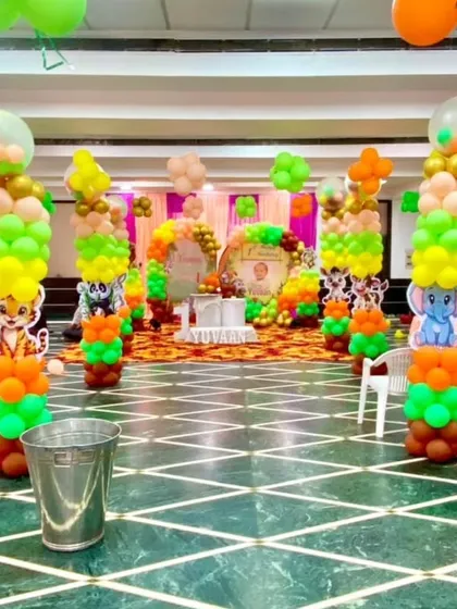 An aisle of jungle-themed balloon pillars leading to the main stage. Each pillar features a different animal cutout, like a lion or an elephant, creating an exciting path for the kids.