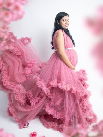 A beautiful portrait surrounded by pink blossoms. The long, flowing ruffled gown in a matching shade of pink creates a stunning and cohesive floral theme.