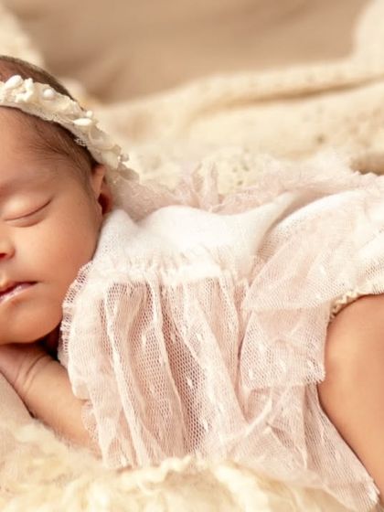 A little angel in lace. This newborn is sleeping peacefully in a delicate outfit, showcasing the beautiful props available in my studio.