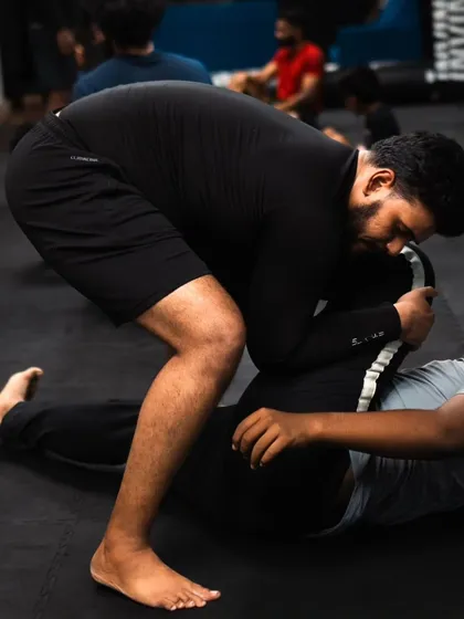 A student applies pressure while trying to pass the guard in a no-gi grappling session.