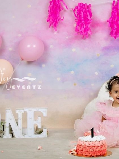 I also arrange professional cake smash photoshoots to capture your baby's first birthday milestone. This session features a pastel-themed backdrop, a 'ONE' marquee sign, and a custom cake, all designed to create beautiful, lasting memories.