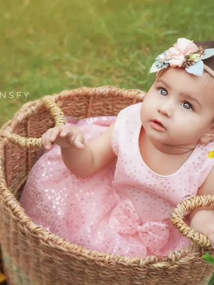 A sweet portrait of a baby girl in a wicker basket, surrounded by nature. Outdoor sessions are perfect for capturing beautiful, light-filled images.