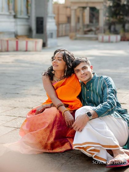 A relaxed moment during a pre-wedding shoot. The couple sits together in a temple courtyard, capturing a slice of everyday love.