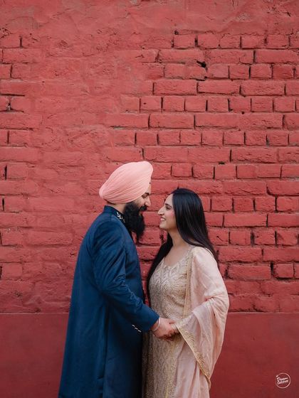 A bold and simple portrait against a striking red brick wall. We use strong colors and clean compositions to create modern and impactful couple portraits that stand out.