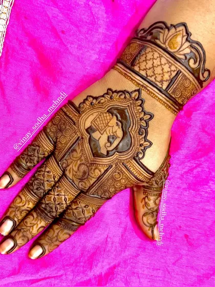 A detailed back-of-hand design with an elephant portrait at the center, framed by intricate patterns and topped with a lotus motif.