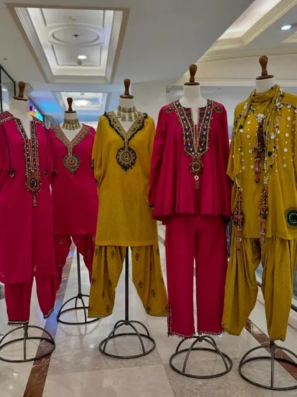 For a playful yet traditional look, I've selected these dhoti-style kurta sets. The vibrant pink and yellow ensembles feature heavy neck embroidery and are perfect for a daytime Diwali party.