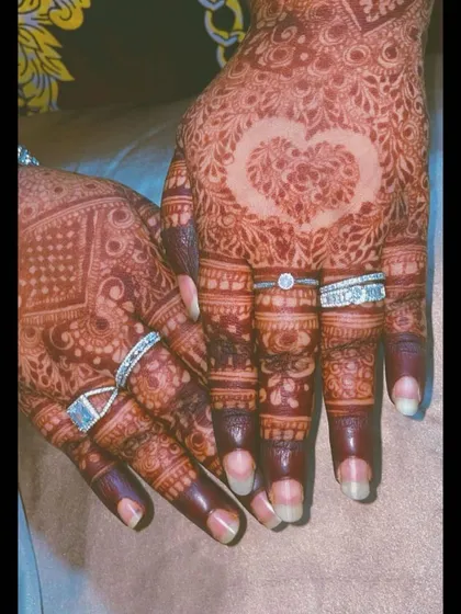 A heart motif left as negative space in the palm, symbolizing love. This is a popular and beautiful way to personalize your engagement henna.
