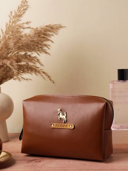 A close-up of the personalized vegan leather pouch, customized with the name 'Ronak' and a horse charm. It's a stylish and practical accessory for organizing essentials.