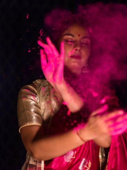 An artistic shot for the festival of Holi, with a cloud of pink color. This image captures the playful and divine camouflage associated with the festival of colors.