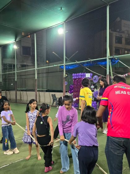 Teamwork makes the dream work. A head coach supervises a spirited game of tug-of-war at a birthday party, where kids learn to work together while having a blast.