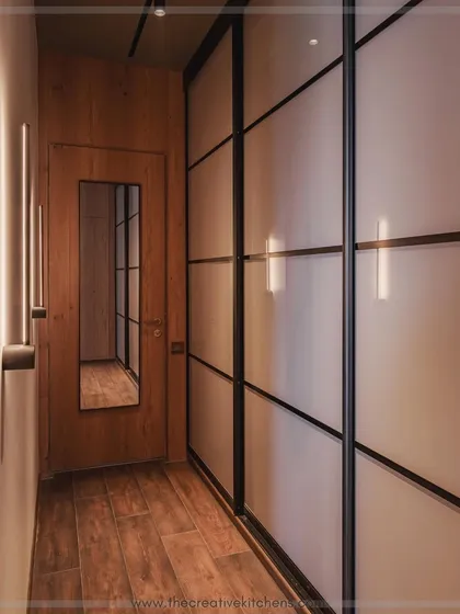 For a look of ultimate minimalist sophistication, we designed this wardrobe with 10-foot-tall profile shutters in sleek, back-painted glass. The seamless, reflective surface makes the space feel larger and more modern.