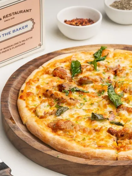 A beautifully baked chicken pizza, fresh out of the oven and ready to be sliced and served.