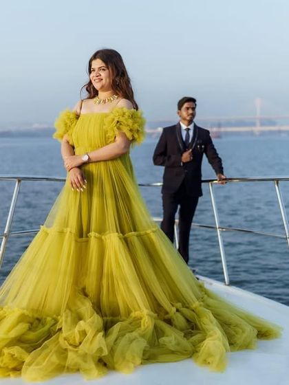 A woman posing on a yacht in a beautiful lime green gown. This shot highlights the dress's elegance and its suitability for a luxurious photoshoot.