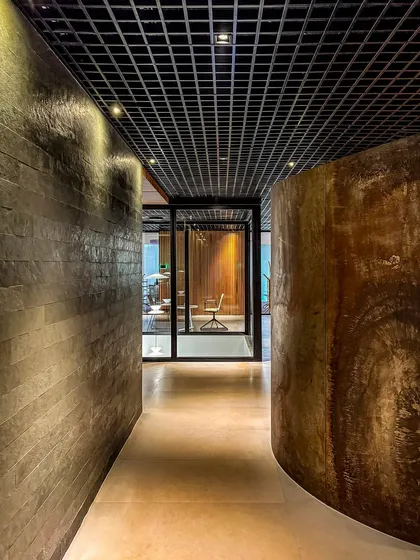A corridor at BCG HQ where curved, textured walls guide the path, demonstrating how we use architectural forms to shape experience and flow.