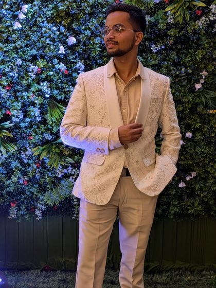 A full-length view of the off-white textured blazer paired with matching trousers. This complete suit for rent provides a polished and elegant look for any formal occasion.