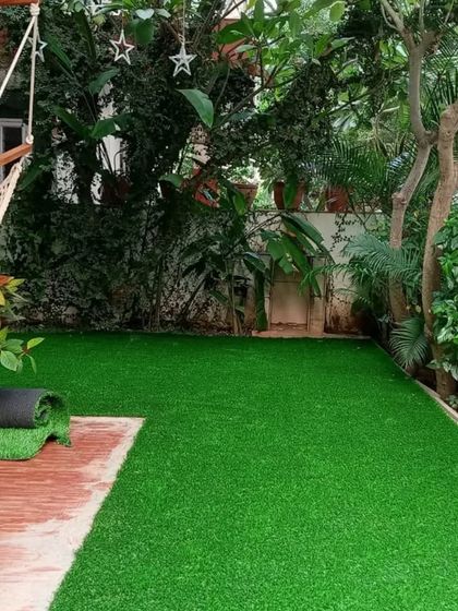 The installation process in action. We carefully cut and fit the turf to the specific shape of the garden area.