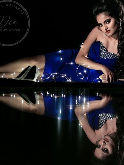 A creative shot showcasing a full party look. The dramatic makeup, combined with the fairy lights, creates a magical and high-fashion feel.