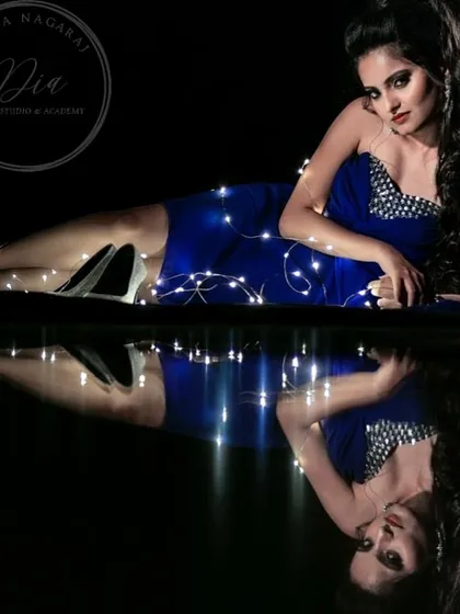 A creative shot showcasing a full party look. The dramatic makeup, combined with the fairy lights, creates a magical and high-fashion feel.