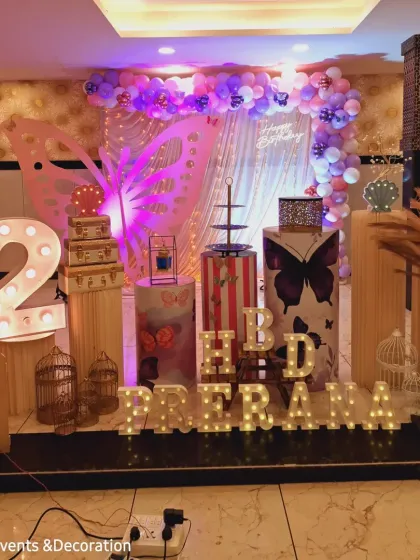 This angle shows the setup process, with the lighting and props being arranged for the butterfly-themed party. It's a peek into the hard work that goes into each event.