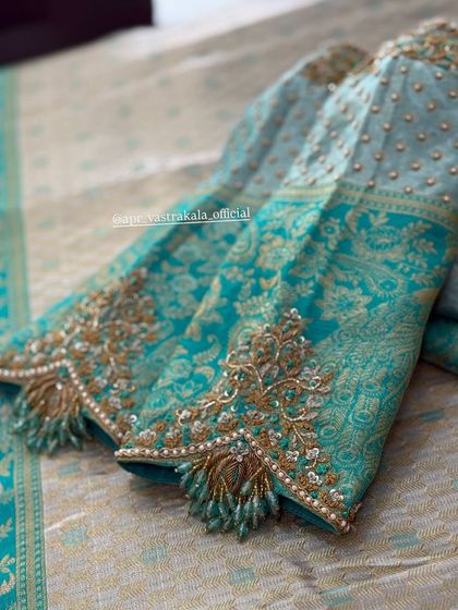 A turquoise brocade blouse with gold floral embroidery and bead tassels.