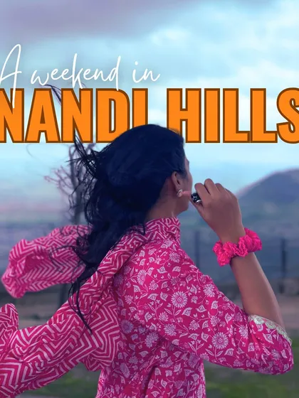 A traveler enjoying the windy morning at Nandi Hills. This popular one-day trip from Bangalore is perfect for catching a beautiful sunrise above the clouds.