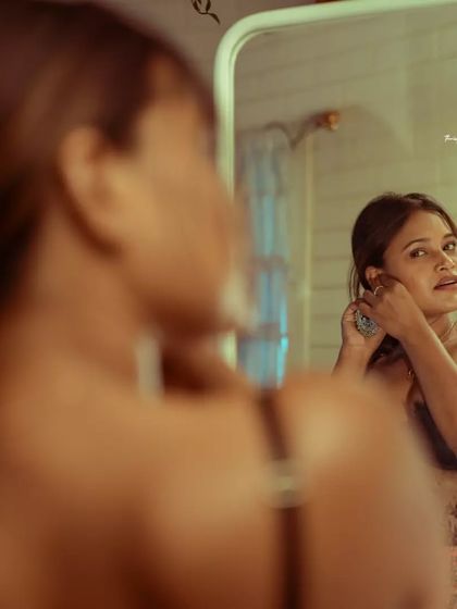 This over-the-shoulder shot focuses on the reflection, creating a thoughtful and slightly distant mood.