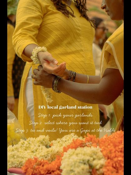 A helper assisting a guest at the DIY garland station. I ensure there is support on hand to make these interactive experiences easy and enjoyable for everyone.