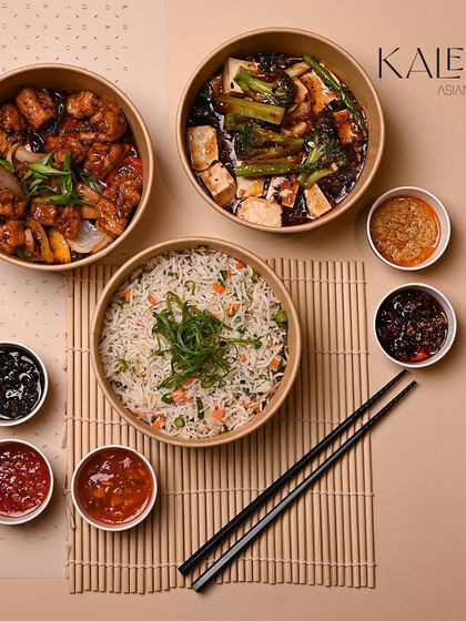A festive meal spread to celebrate any occasion. This image shows multiple main dishes and fried rice in our delivery bowls, surrounded by our selection of flavorful sauces.