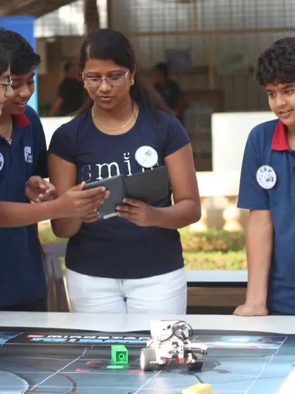 A team of students strategizes around the competition table during an Indian Robotics Olympiad orientation at our Whitefield center. These sessions are designed to introduce the challenges and inspire participation.