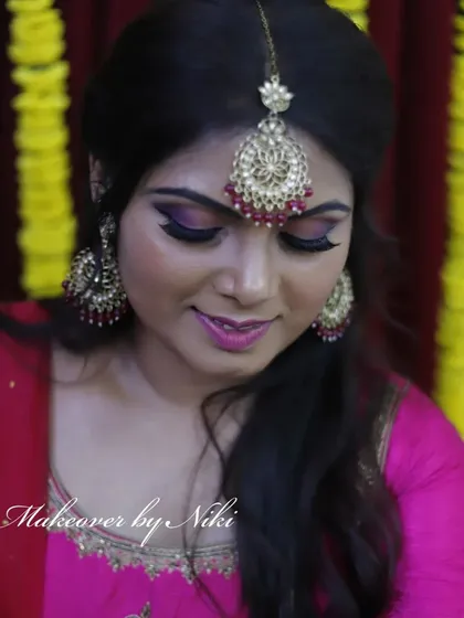 A close-up of Namratha's minimal and natural mehendi makeup. The focus is on a dramatic purple smokey eye and a matching lip color.